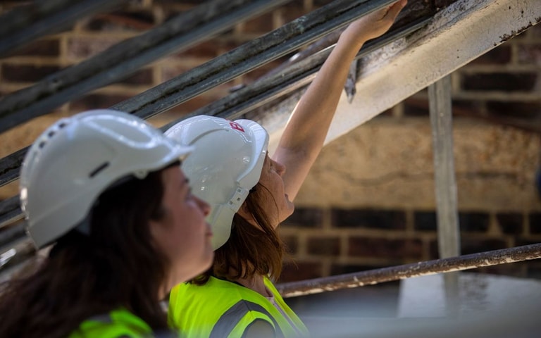 Two women on building site in hard hats